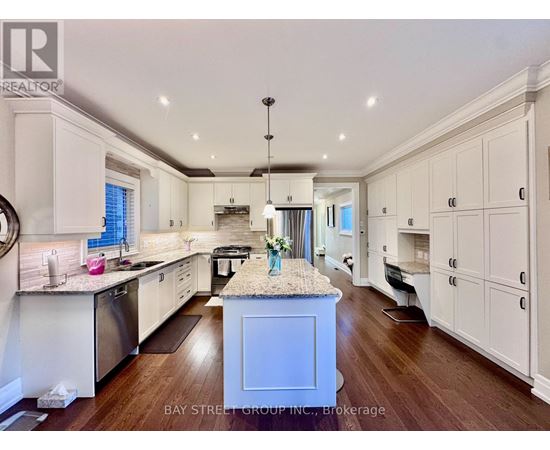 A kitchen with white cabinets and a granite island.