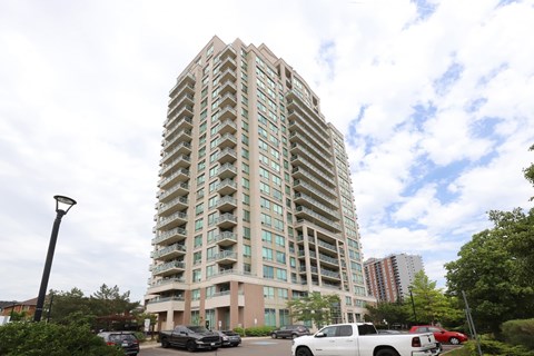 A tall building with a parking lot in front of it.