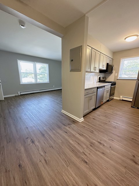 A kitchen with wooden floors and white walls.