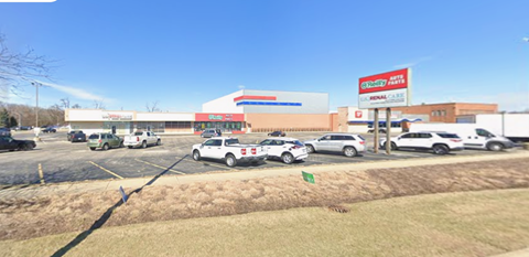 A parking lot with cars and a building with a sign that says "Easy Mart".