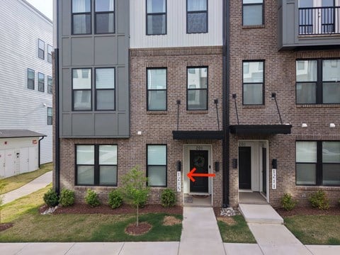 A building with a black door and a red arrow pointing to it.