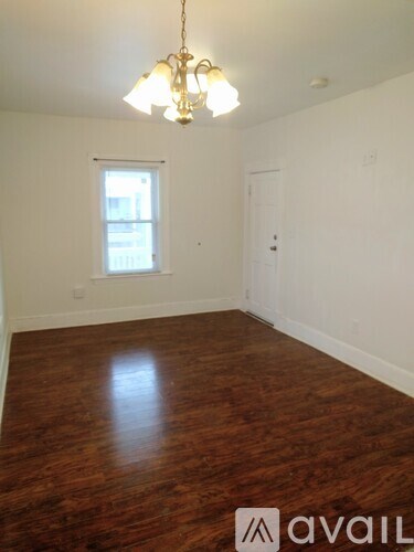 A room with wooden floors and a chandelier.