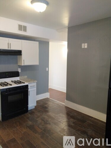 A kitchen with a black stove top oven and white cabinets.