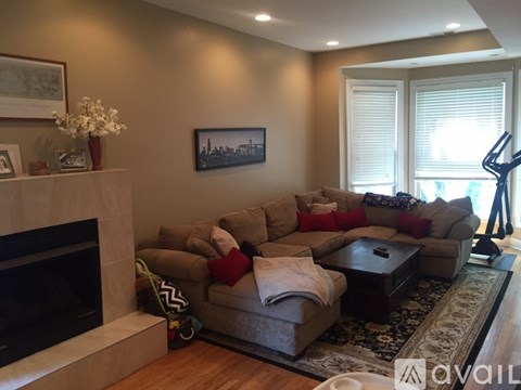 A living room with a fireplace and a painting on the wall.