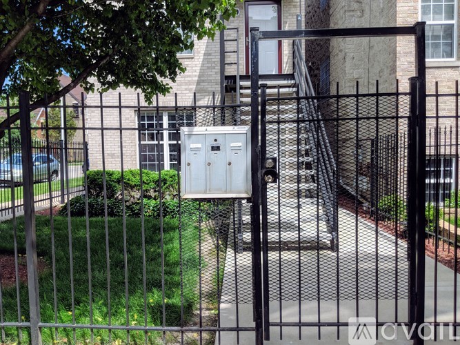 A black metal fence with a gate is in front of a building.