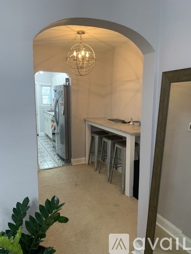 A kitchen area with a fridge, table and chairs.