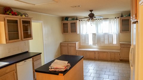A kitchen with wooden cabinets and a black countertop.