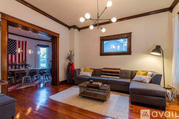 A living room with a grey couch and a wooden floor.
