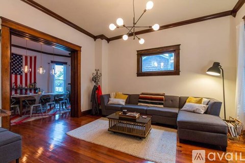 A living room with a grey couch and a wooden floor.