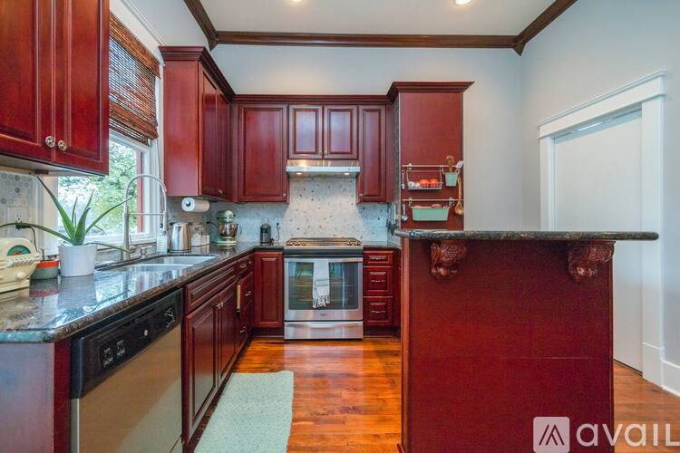A kitchen with red cabinets and a black countertop.