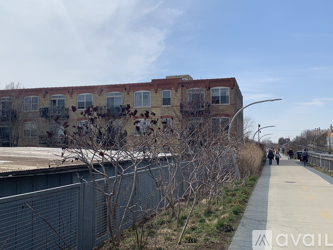 A building with a fence and a sidewalk in front of it.