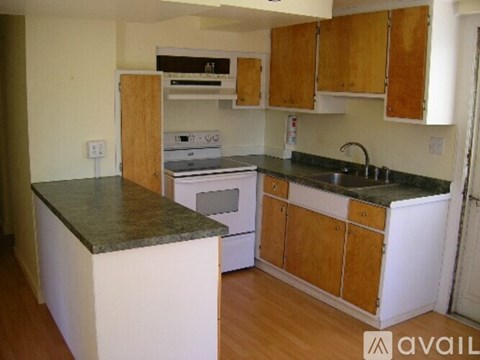 A kitchen with wooden cabinets and a granite counter top.