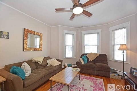 A living room with a brown couch and a wooden coffee table.