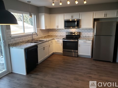 A kitchen with white cabinets and a black stove top oven.