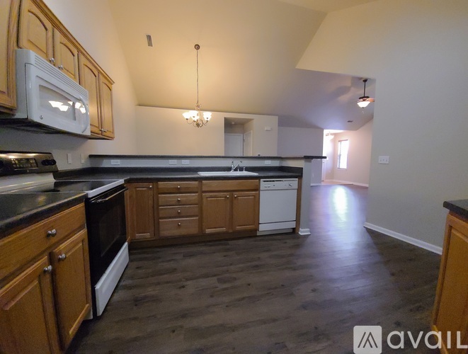 A kitchen with wooden cabinets and a black countertop.