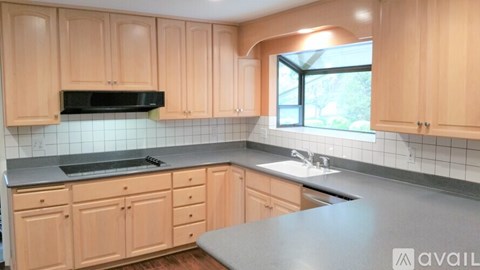 A kitchen with wooden cabinets and a black countertop.