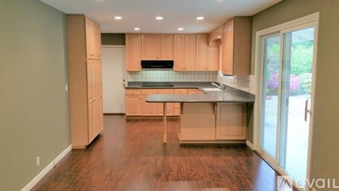 A kitchen with wooden cabinets and a stainless steel island.