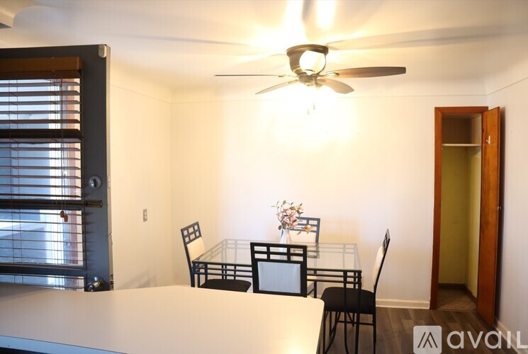 A dining room with a table, chairs, and a ceiling fan.