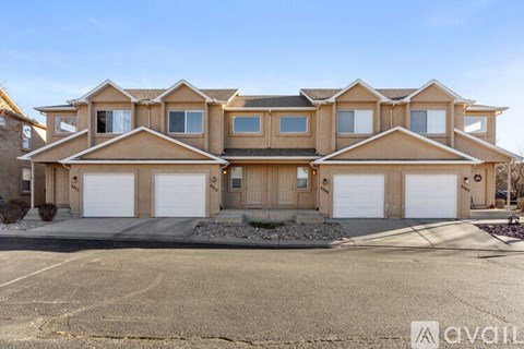 A large, multi-story house with a driveway in front.