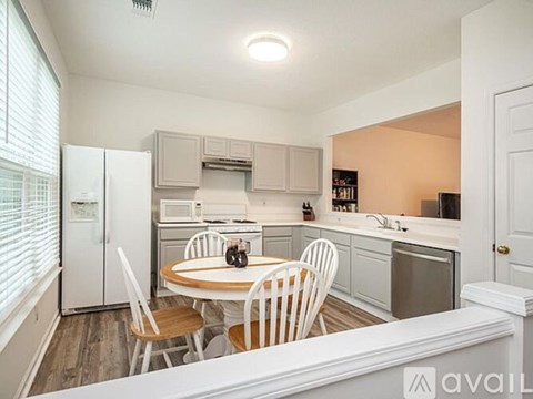 A kitchen with a table and chairs in the middle of the room.