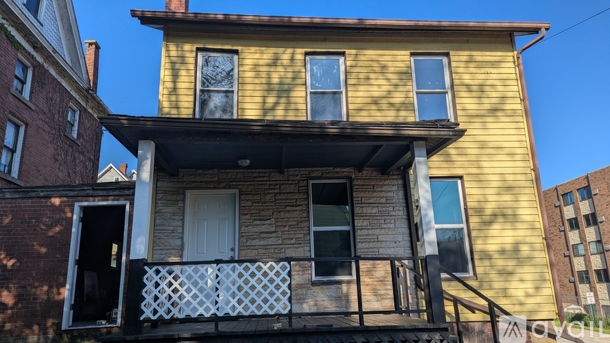A yellow house with a balcony and a door.