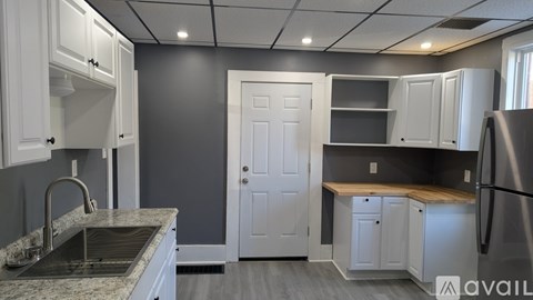 A kitchen with white cabinets and a granite countertop.