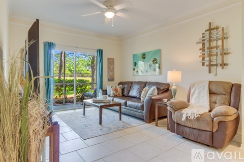 A living room with a brown couch and a painting on the wall.