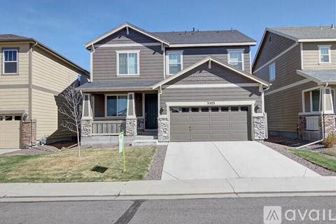 A house with a garage and a driveway in front of it.