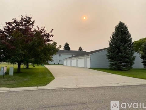 A house with a driveway and a tree in front of it.