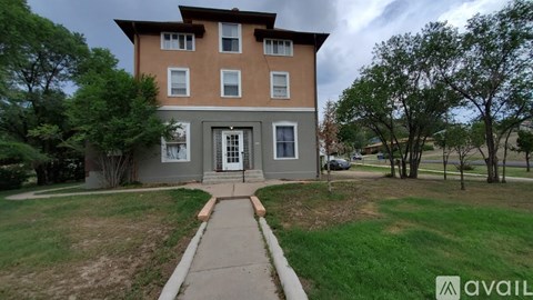 A two-story house with a front yard and a walkway leading to the entrance.