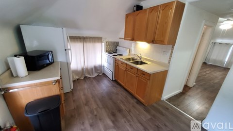 A kitchen with wooden cabinets and a white fridge.