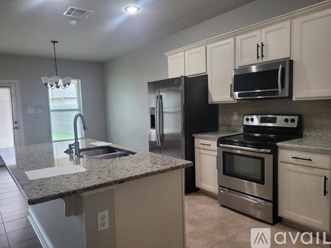 A kitchen with granite countertops and stainless steel appliances.