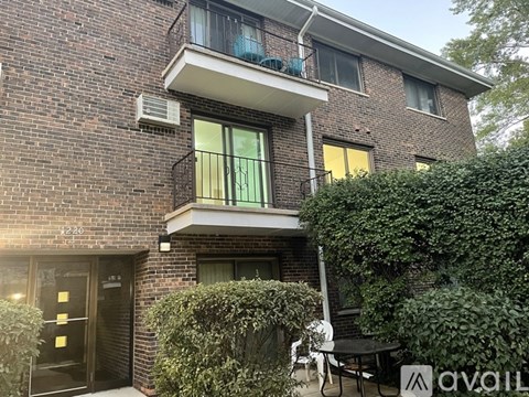 A brick building with a balcony and a door with a gold handle.