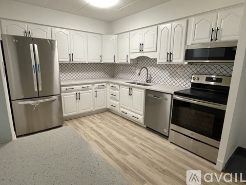 A kitchen with white cabinets and stainless steel appliances.