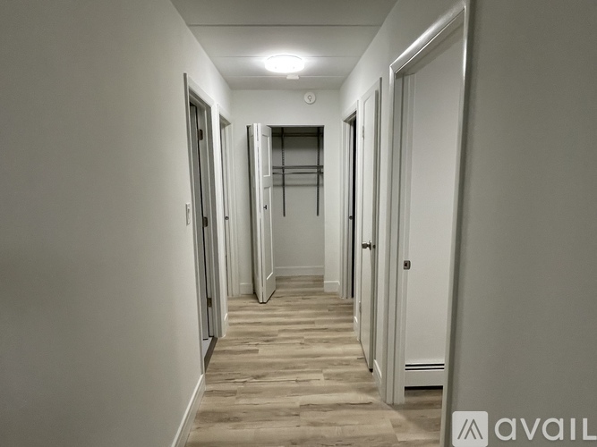 A long hallway with doors on both sides and a light on the ceiling.