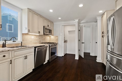A kitchen with wooden cabinets and a stainless steel refrigerator.
