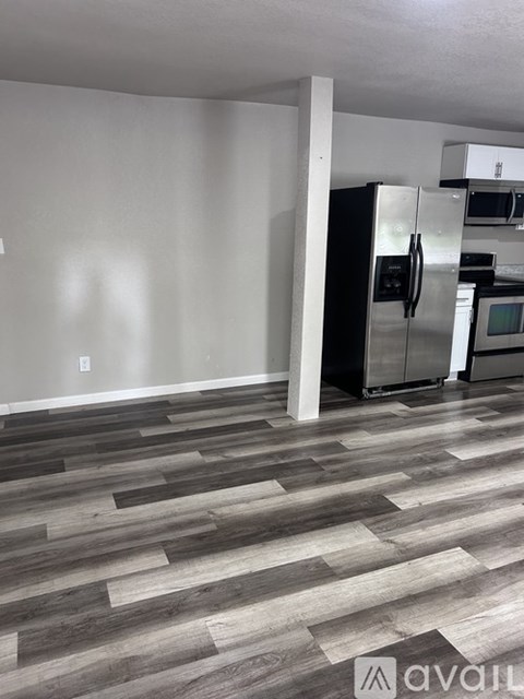 A kitchen with a refrigerator and microwave.