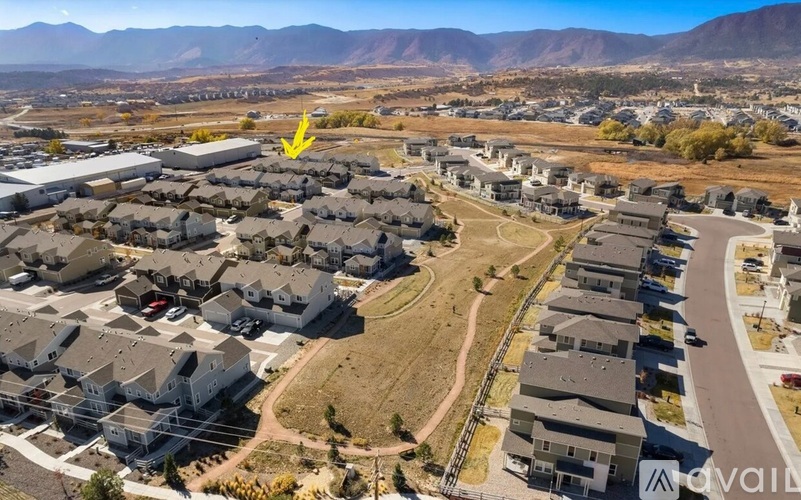 A bird's eye view of a residential area with a yellow arrow pointing to a specific house.
