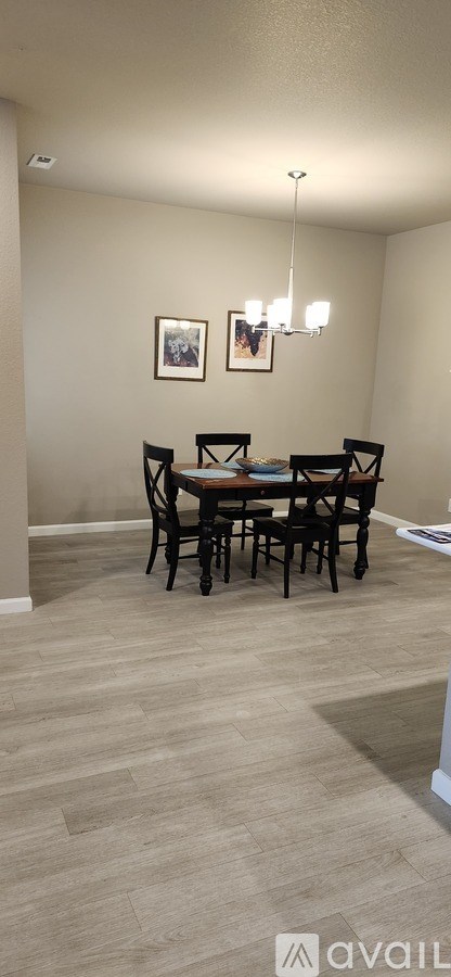 A dining room with a table and chairs.