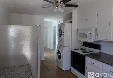 A kitchen with white cabinets and a black stove top oven.