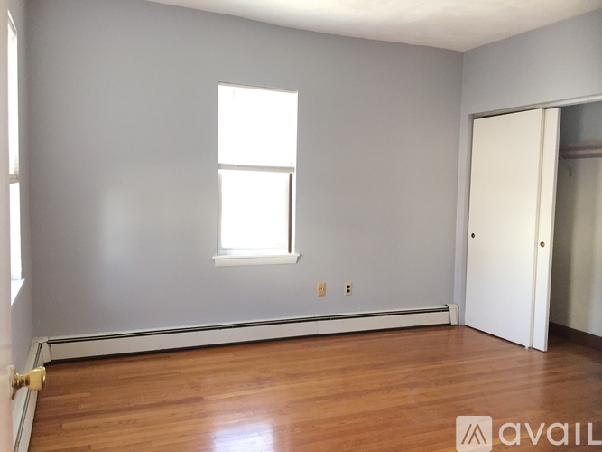 A room with a wooden floor and a window.