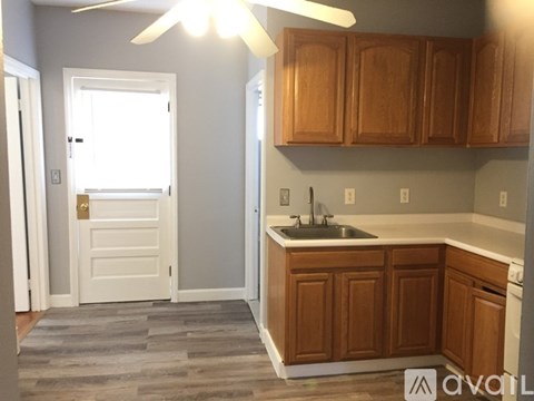 A kitchen with wooden cabinets and a white door.