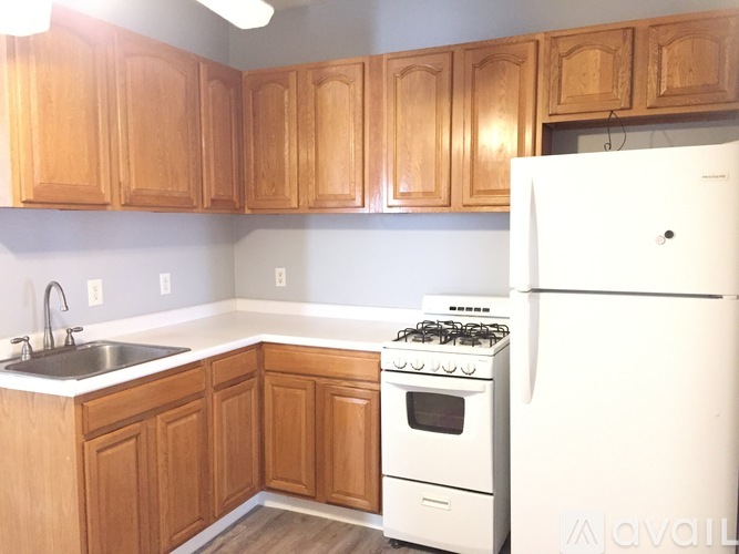 A kitchen with wooden cabinets and a white refrigerator.