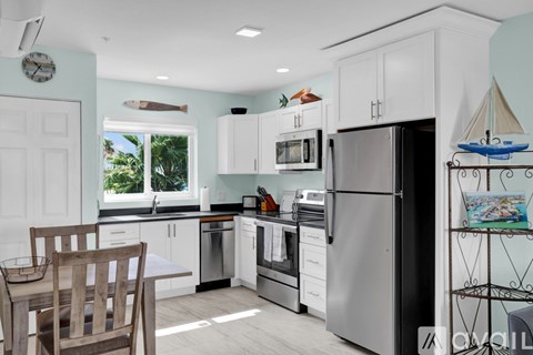 A kitchen with a wooden chair and a fridge.