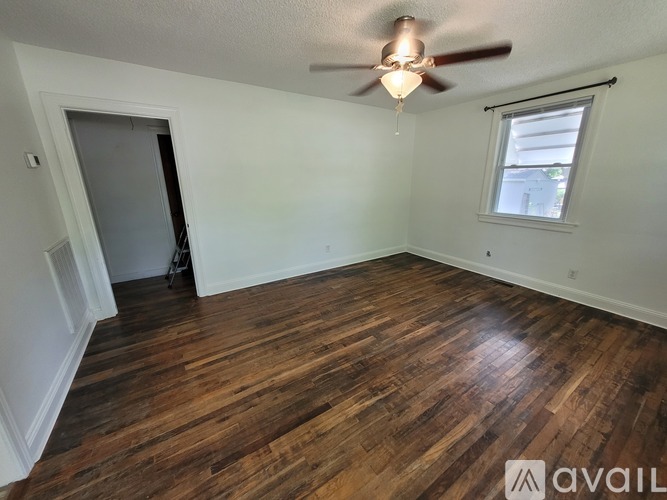 A room with wooden flooring and a ceiling fan.