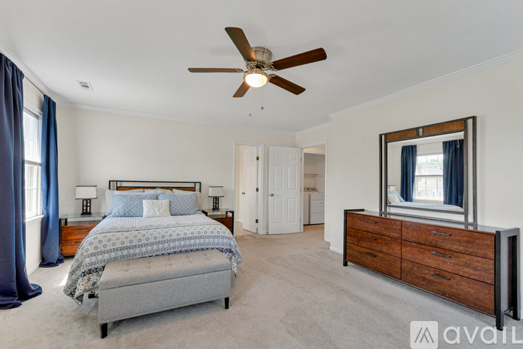 A bedroom with a bed, dresser, and window.
