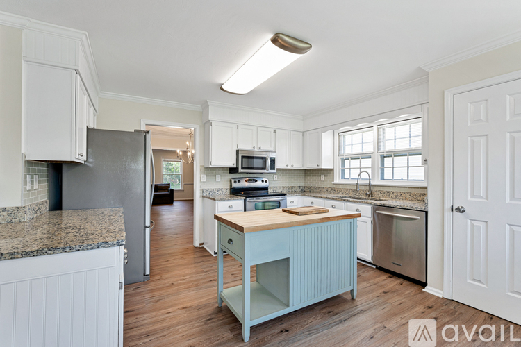 A kitchen with a granite counter top and a wooden island.