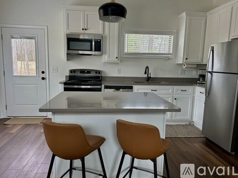 A kitchen with a stove top oven and a refrigerator.