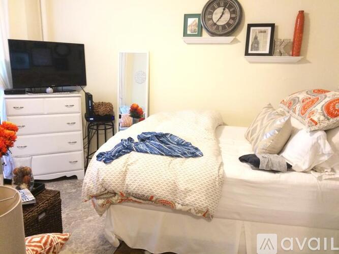 A bedroom with a bed, dresser, and television.