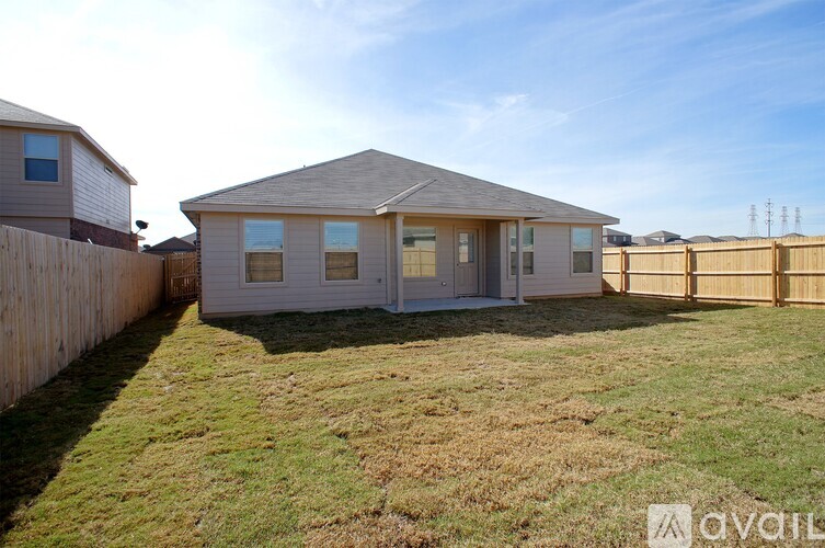 A house with a fence and grass in front is available for rent.